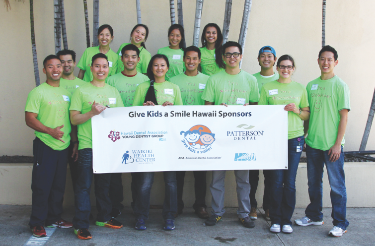 The Hawaii Dental Association Young Dentist Group volunteers hold up a Give Kids A Smile Hawaii banner at their Feb. 21 GKAS event. Pictured at the top, from left: Drs. Tina Mukai, Lauren Young, Keri Wong and Jaclyn Palola.  At bottom, from left: Drs. Blake Kitamura, Robert Yong, Scott Morita, Bryan Sato, Suzan Ly, Christopher Young, Scott Hiramoto, Wesley Sato, Rachel Dipasquale and Blake Matsuura.